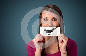 Happy cute girl holding paper with funny smiley drawing