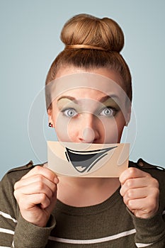 Happy cute girl holding paper with funny smiley drawing