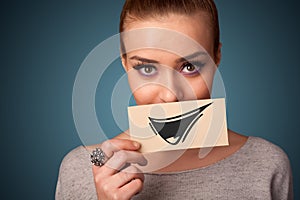 Happy cute girl holding paper with funny smiley drawing