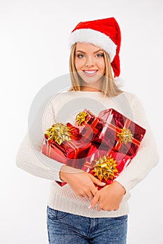 Happy cute girl in santa hat with Christmas presents