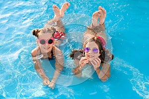 Happy cute girls in swimming pool