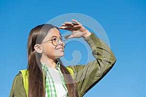 Happy cute kid in eyeglasses look ahead sunny blue sky outdoors, future