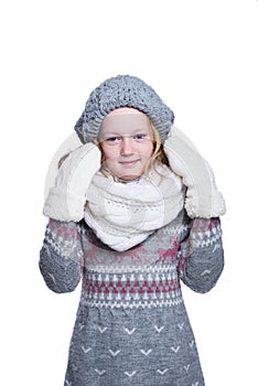 Happy cute kid posing in the studio isolated on white background. Wearing winter clothes. Knitted woolen sweater, scarf, hat.