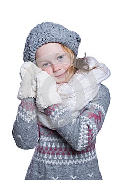 Happy cute kid posing in the studio isolated on white background. Wearing winter clothes. Knitted woolen sweater, scarf, hat and