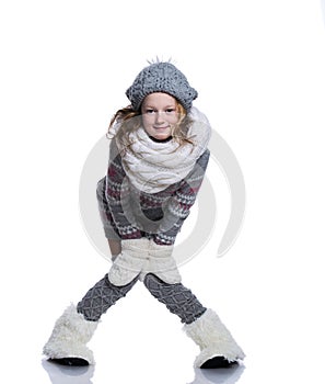 Happy cute kid posing in the studio isolated on white background. Wearing winter clothes. Knitted woolen sweater, scarf, hat