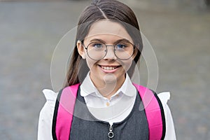 Happy cute kid smile wearing eyeglasses in school uniform outdoors, future