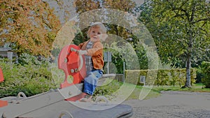 Happy cute little child having fun playing with colorful wooden toys in the park, sunny warm autumn day in children playground