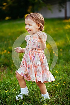 Happy cute little girl running on the grass in the park. Happiness