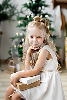 Happy cute little smiling girl with christmas gift box. Merry Christmas and Happy Holidays.