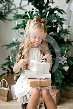 Happy cute little smiling girl with christmas gift box. Merry Christmas and Happy Holidays.