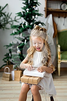 Happy cute little smiling girl with christmas gift box. Merry Christmas and Happy Holidays.