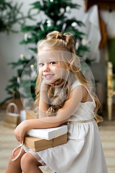 Happy cute little smiling girl with christmas gift box. Merry Christmas and Happy Holidays.