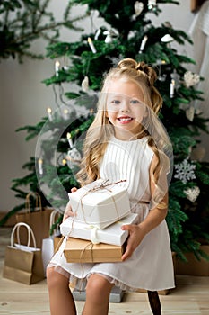 Happy cute little smiling girl with christmas gift box. Merry Christmas and Happy Holidays.