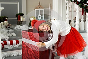 Happy cute little smiling girl with christmas gift box. Merry Christmas and Happy Holidays.