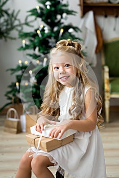 Happy cute little smiling girl with christmas gift box. Merry Christmas and Happy Holidays.