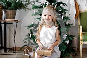 Happy cute little smiling girl with christmas gift box. Merry Christmas and Happy Holidays.