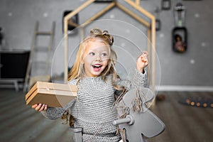 Happy cute little smiling girl with christmas gift box. Merry Christmas and Happy Holidays.