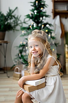 Happy cute little smiling girl with christmas gift box. Merry Christmas and Happy Holidays.