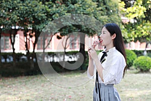 Happy cute lovely beautiful young girl high school college student enjoy free time eat icecream