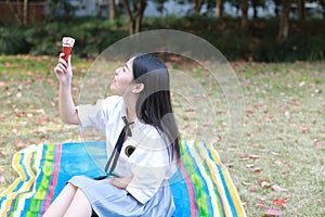 Happy cute lovely beautiful young girl high school college student enjoy free time eat icecream