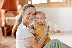 Happy cute mother and little baby boy smiling at camera