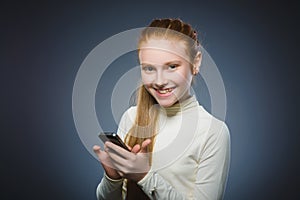 Happy cute redhead girl with cell phone. isolated on gray