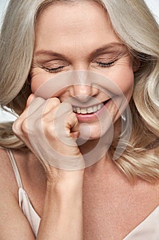 Happy cute shy middle aged woman laughing. Anti age face skin care, closeup view