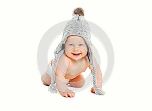 Happy cute smiling baby in knitted grey hat crawls on white
