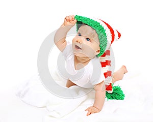 Happy cute smiling baby in knitted hat crawls on white