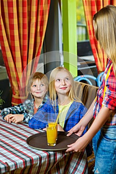 Happy cute smiling girl waiter holding a tray with