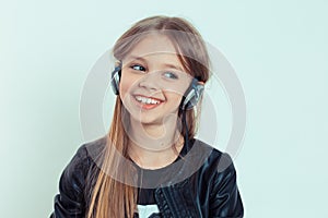 Happy cute smiling kid girl listening to music in her headphones