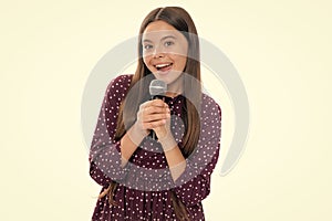 Happy cute teen girl singing a song on microphone. Close-up portrait of trendy fashionable girl singing karaoke