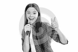 Happy cute teen girl singing a song on microphone. Close-up portrait of trendy fashionable girl singing karaoke