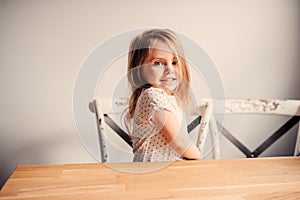 Happy cute toddler girl playing at home in kitchen