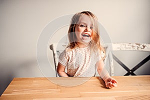 Happy cute toddler girl playing at home in kitchen