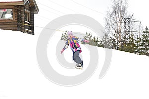 Happy cute young girl snowboarding on a snow slope at ski resort