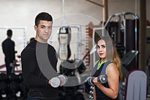 Happy cutie athletic girl and guy, exercise with dumbbells and smile