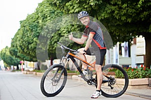 Happy cyclist showing thumbs up riding bike