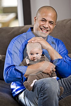 Happy dad with baby sitting on lap