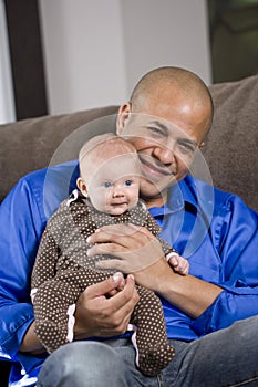 Happy dad with baby sitting on lap