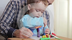 Happy dad and child together playing with plasticine