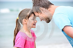 Happy dad and daughter are butting heads cheerfully photo