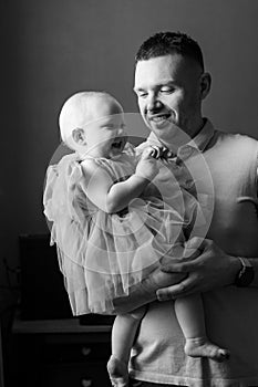 Happy dad holding little daughter in his arms. fatherhood.