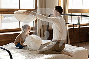 Happy dad involved in pillow fight with little daughter