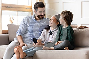 Happy dad and kids use cellphone relaxing at home
