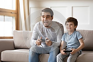 Happy dad and little son play video game