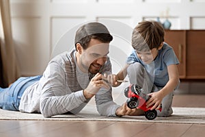 Happy dad play with toy car with small son