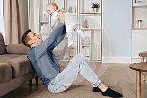 Happy dad playing with his little baby at home