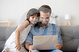 Happy dad relax watching cartoons with little daughter