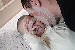 Happy dad and son having fun at home. Father and baby boy in bedroom on a bright background. Tenderness, parenthood